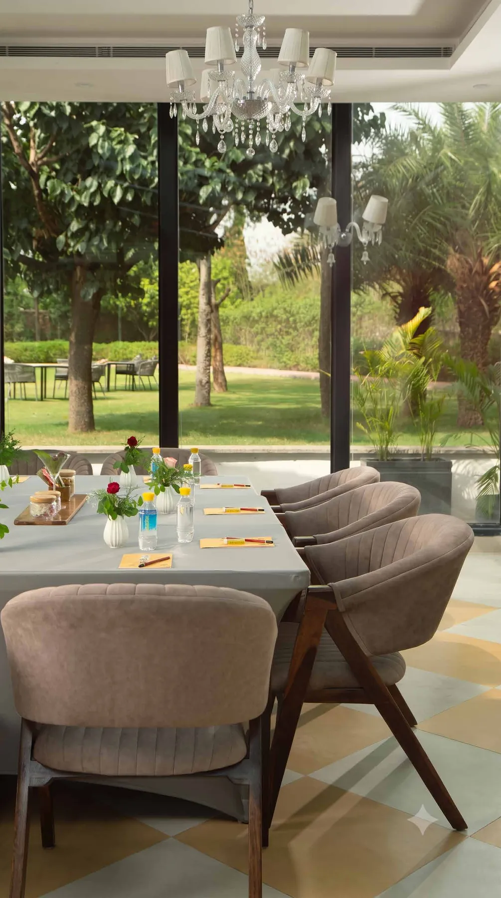 A lounge chair inside The Glasshouse looking out at the lawn
